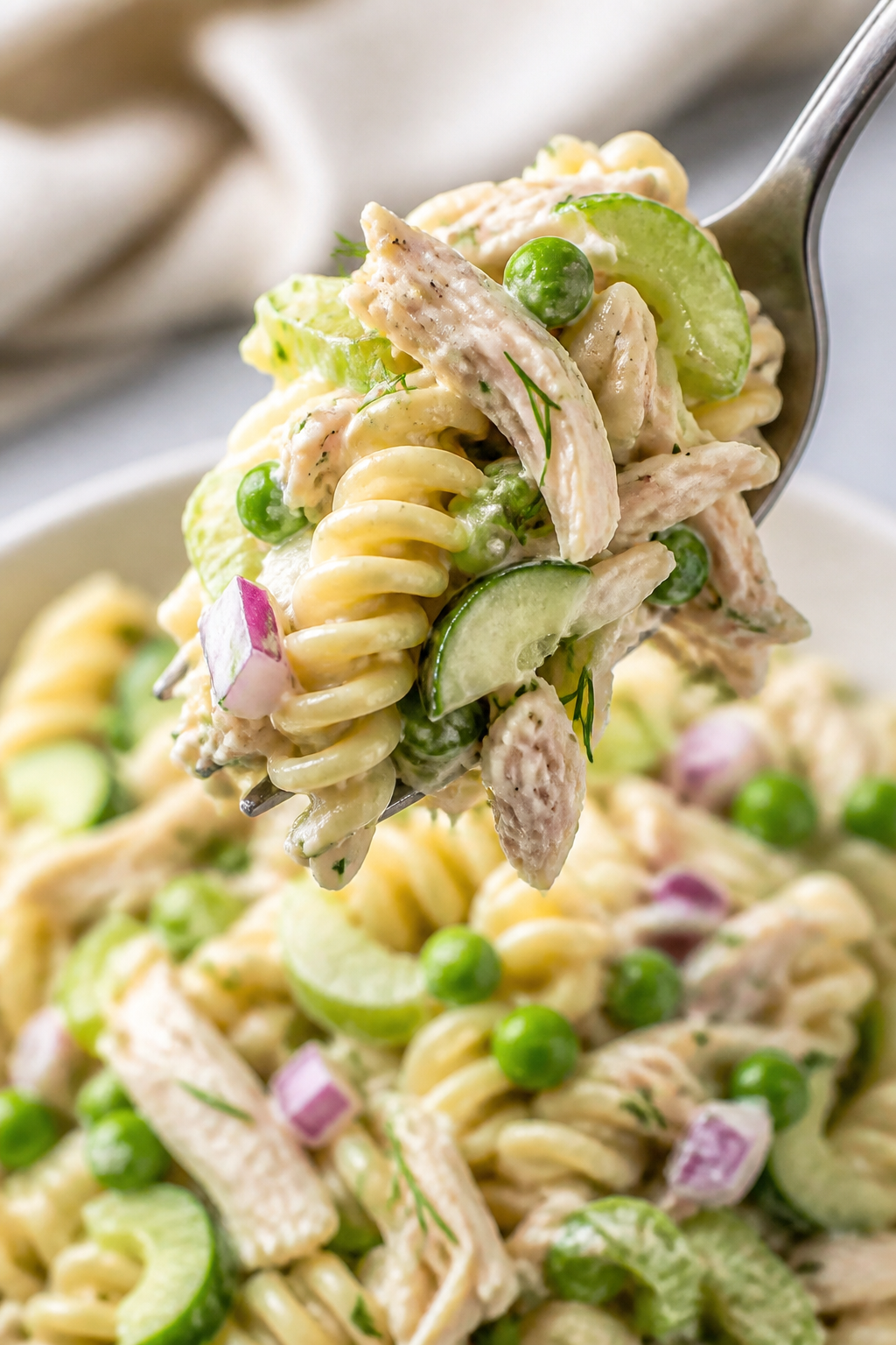 Close-up detail: Creamy Dill Chicken Pasta Salad, macro shot of a forkful lifted above a plate—spi