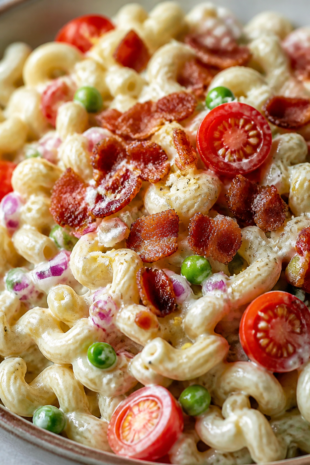 Close-up detail: Crispy, deeply golden diced bacon scattered over creamy garlic-butter pasta salad, 