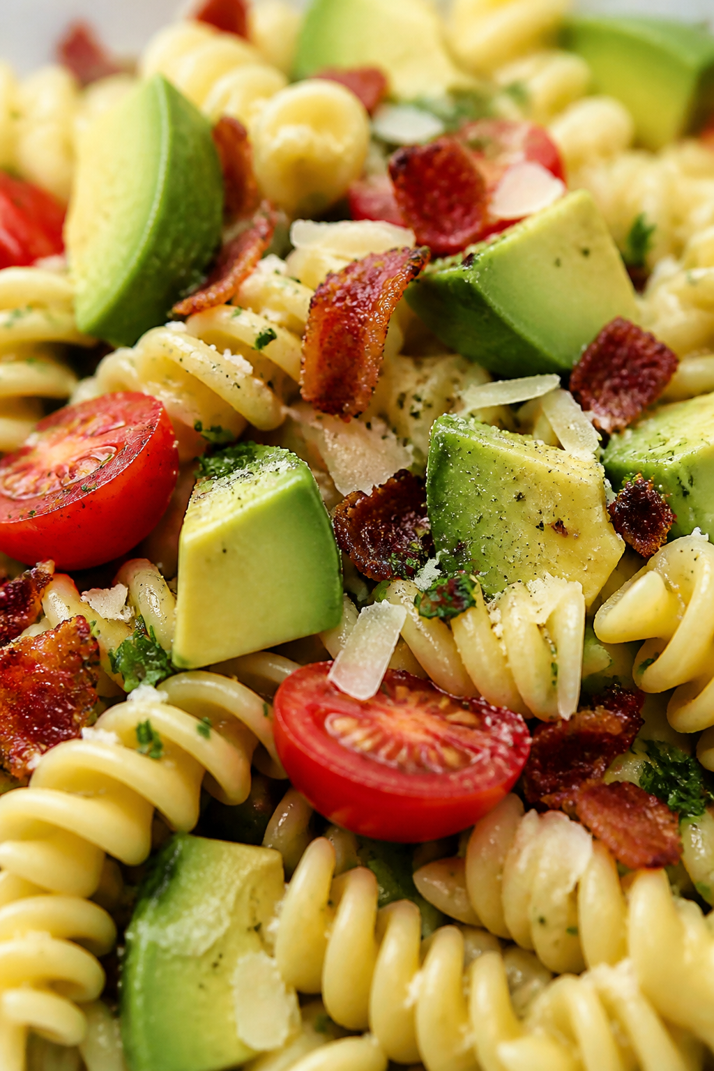 Close-up detail: Gently folded diced avocado nestled into the salad at the end, showing creamy green
