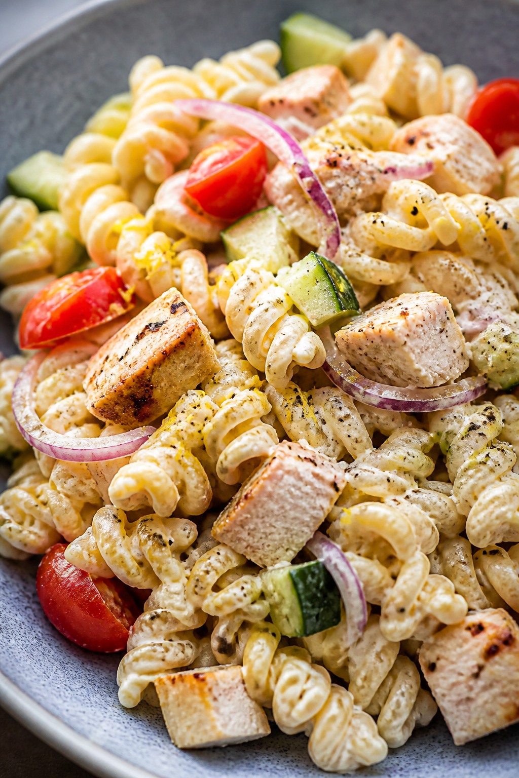 Close-up detail shot: A mound of al dente rotini pasta tossed in creamy Parmesan–Greek yogurt dres