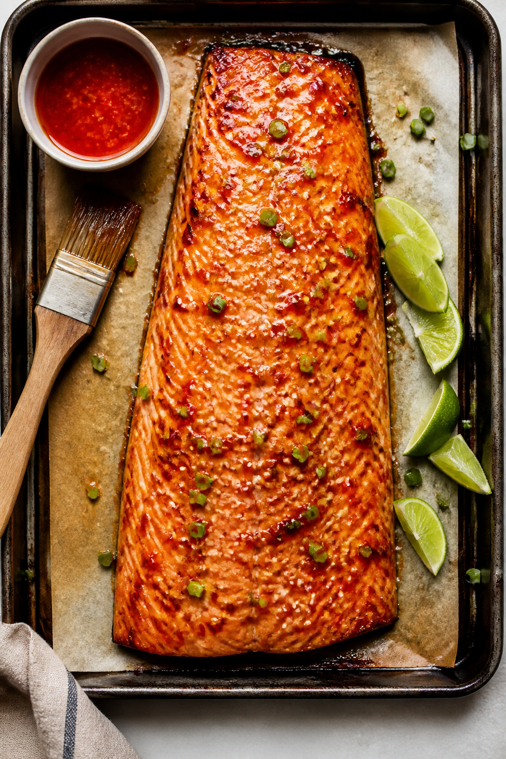 Tasty : Overhead shot of a whole side of sweet chili glazed salmon on a rimmed sheet pan, post-broil
