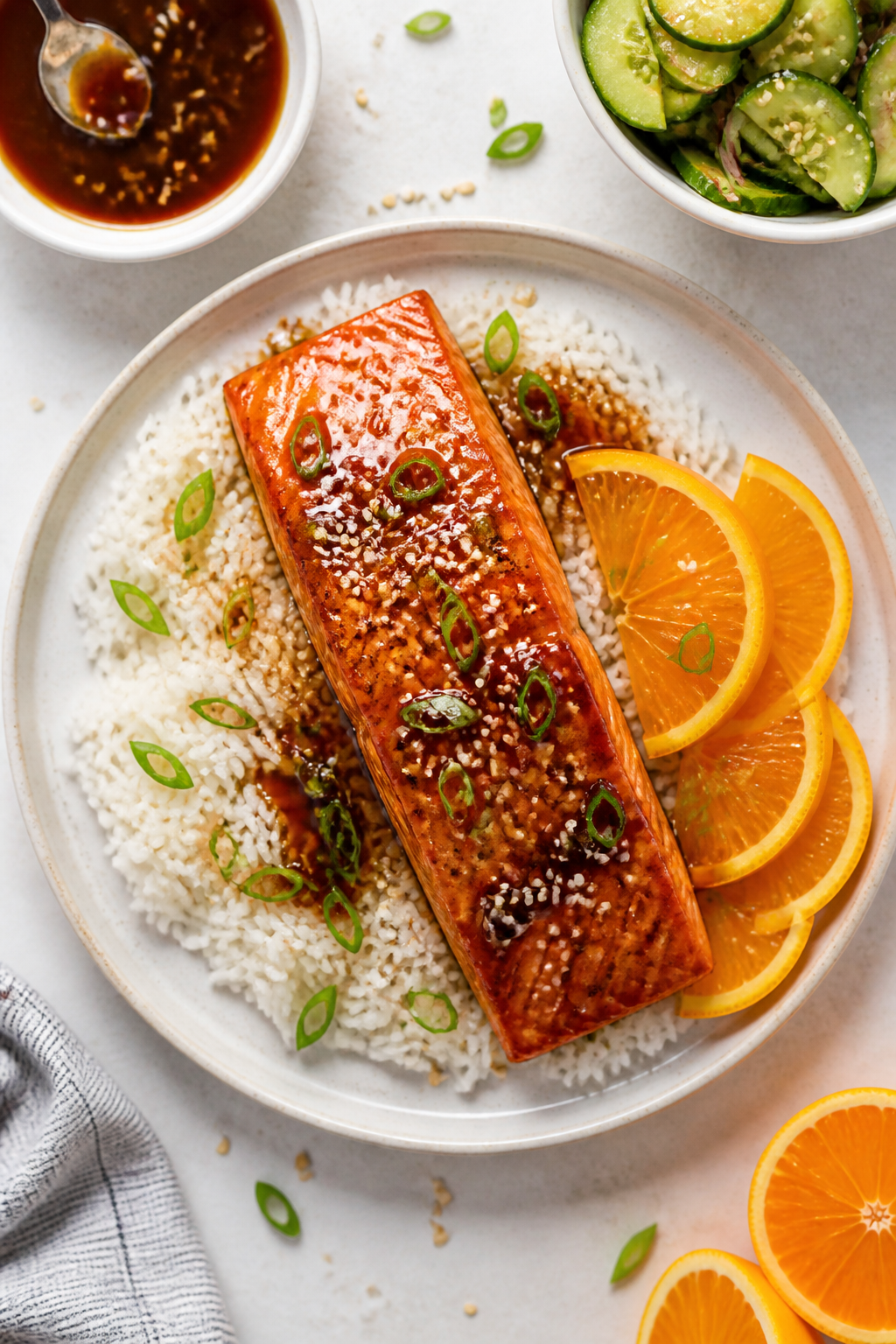 Tasty top view final dish: Overhead shot of beautifully plated sticky orange honey salmon on a white