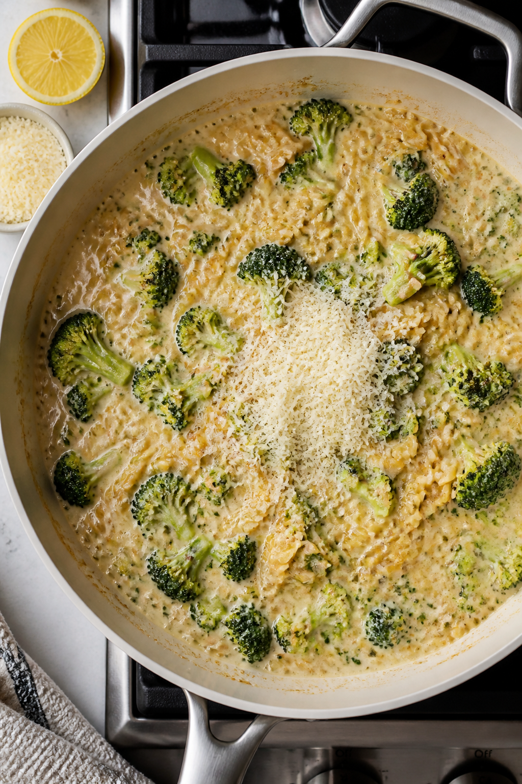 Tasty top view: Overhead shot of the one-pan orzo simmering stage in a wide, light-colored sauté pa
