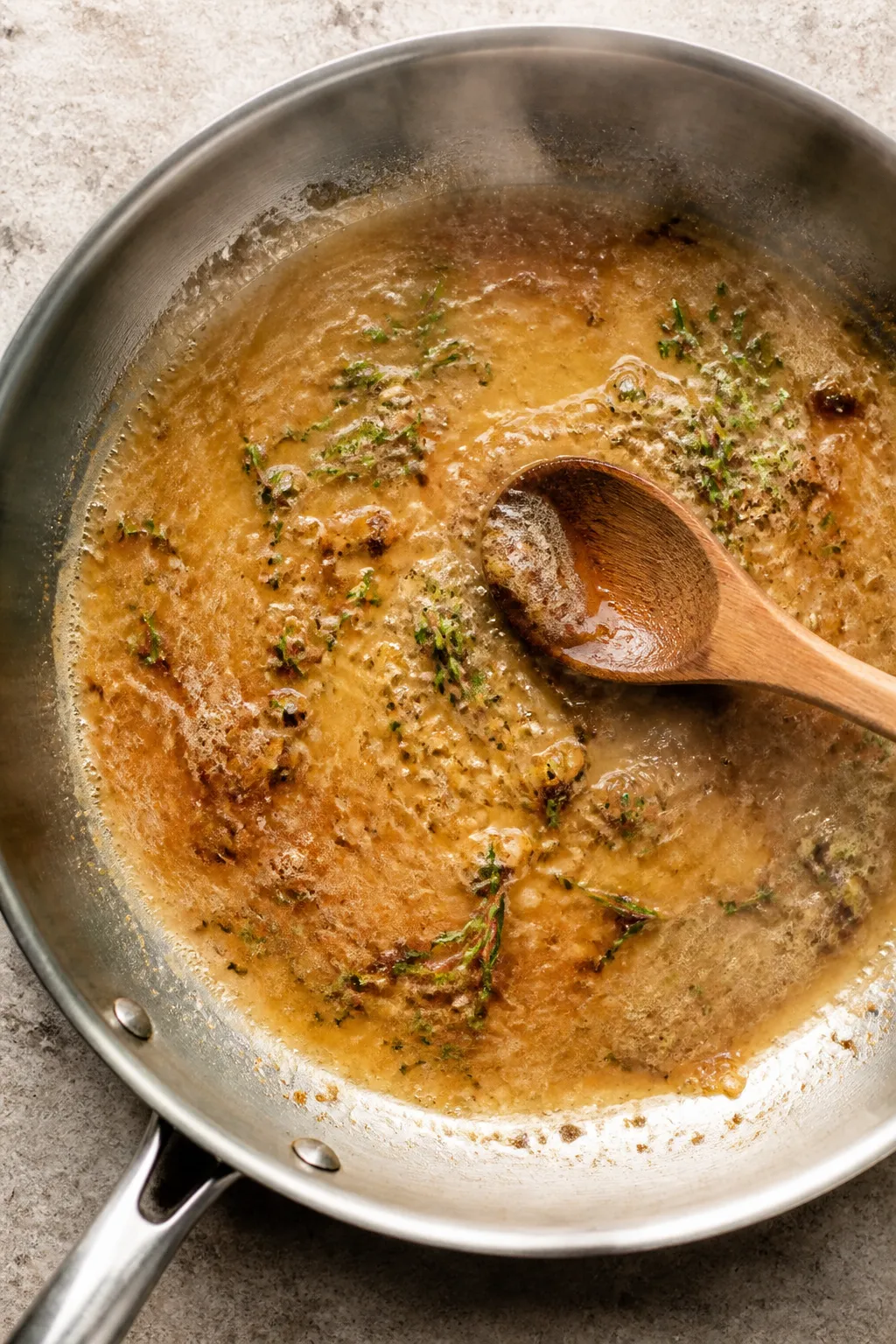 Cooking process: Overhead shot of the deglazing stage—silky garlic butter sauce simmering in a sta