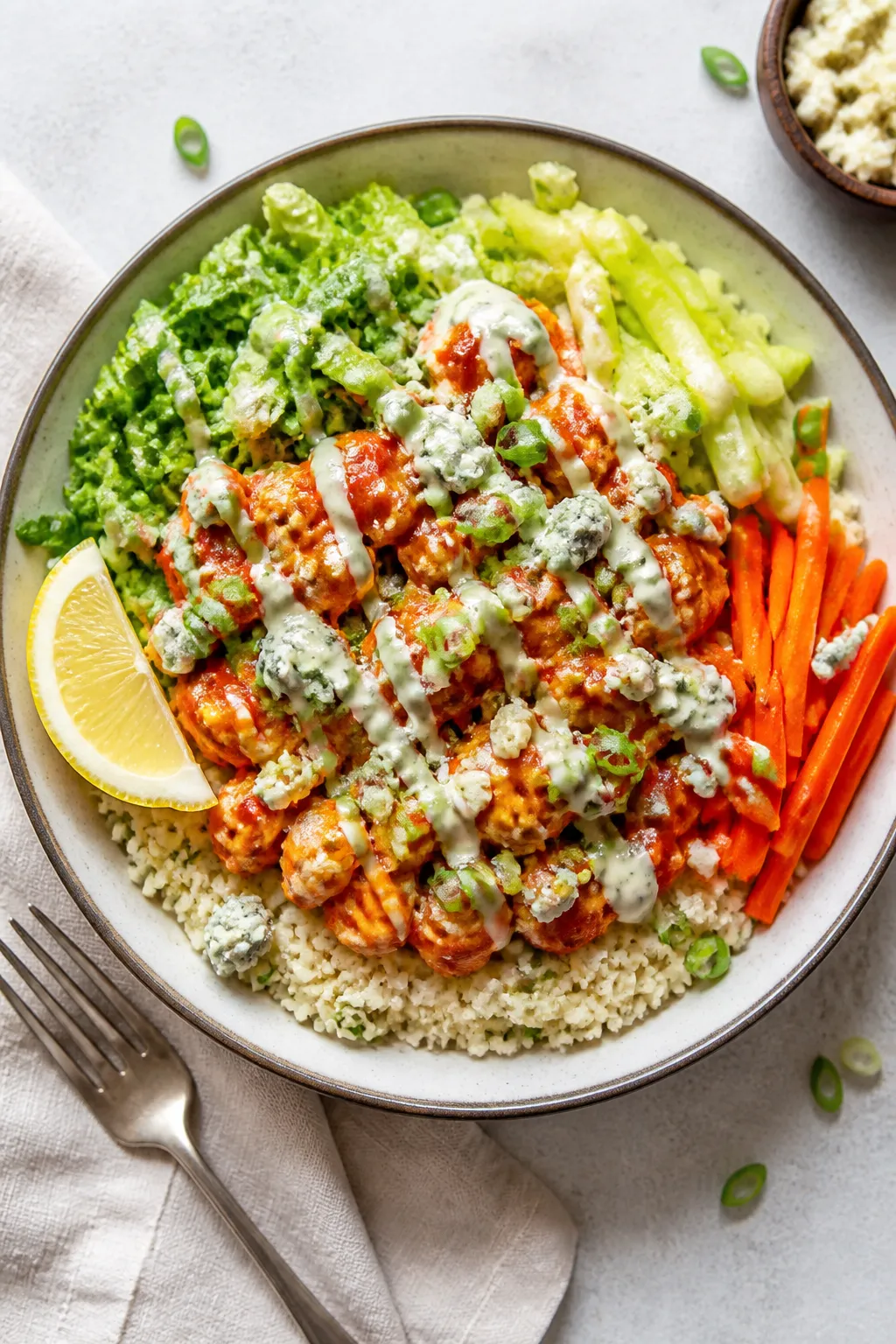 Tasty top view: Fully assembled Buffalo Chicken Cauliflower Rice Bowl in a wide, shallow ceramic bow