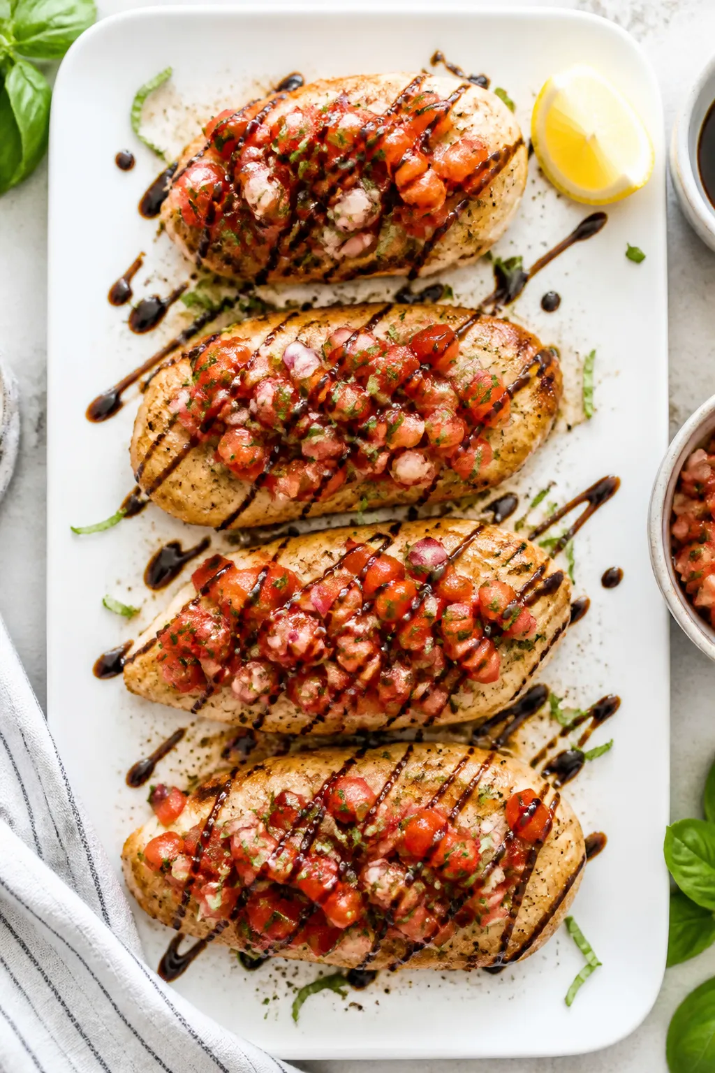 Tasty top view: Overhead shot of assembled Low Carb Bruschetta Chicken on a white ceramic platter—
